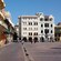 People walk by 17th century colonial buildings in a colonial plaza in old town Cartagena